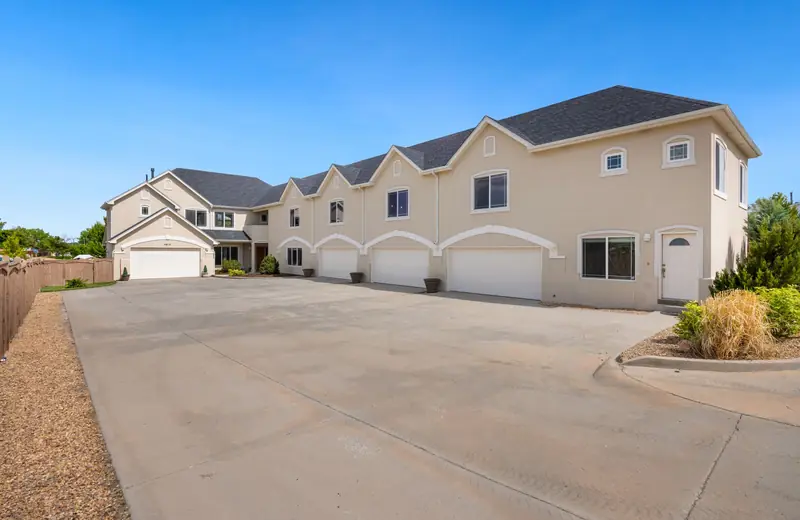 Wide concrete driveway in front of a row of homes