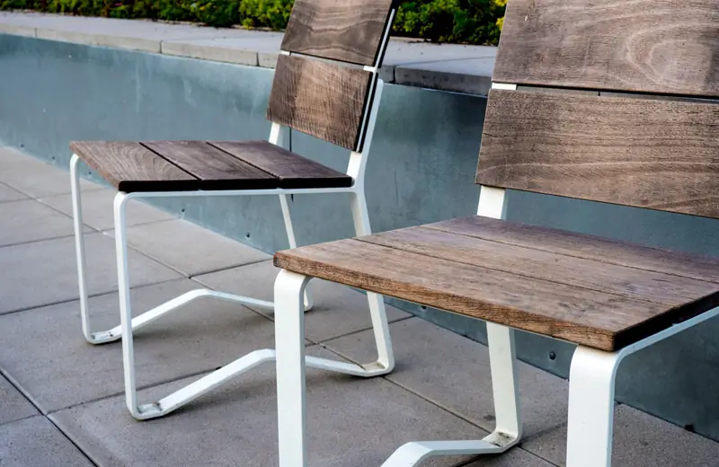 Two wooden chairs on a concrete patio